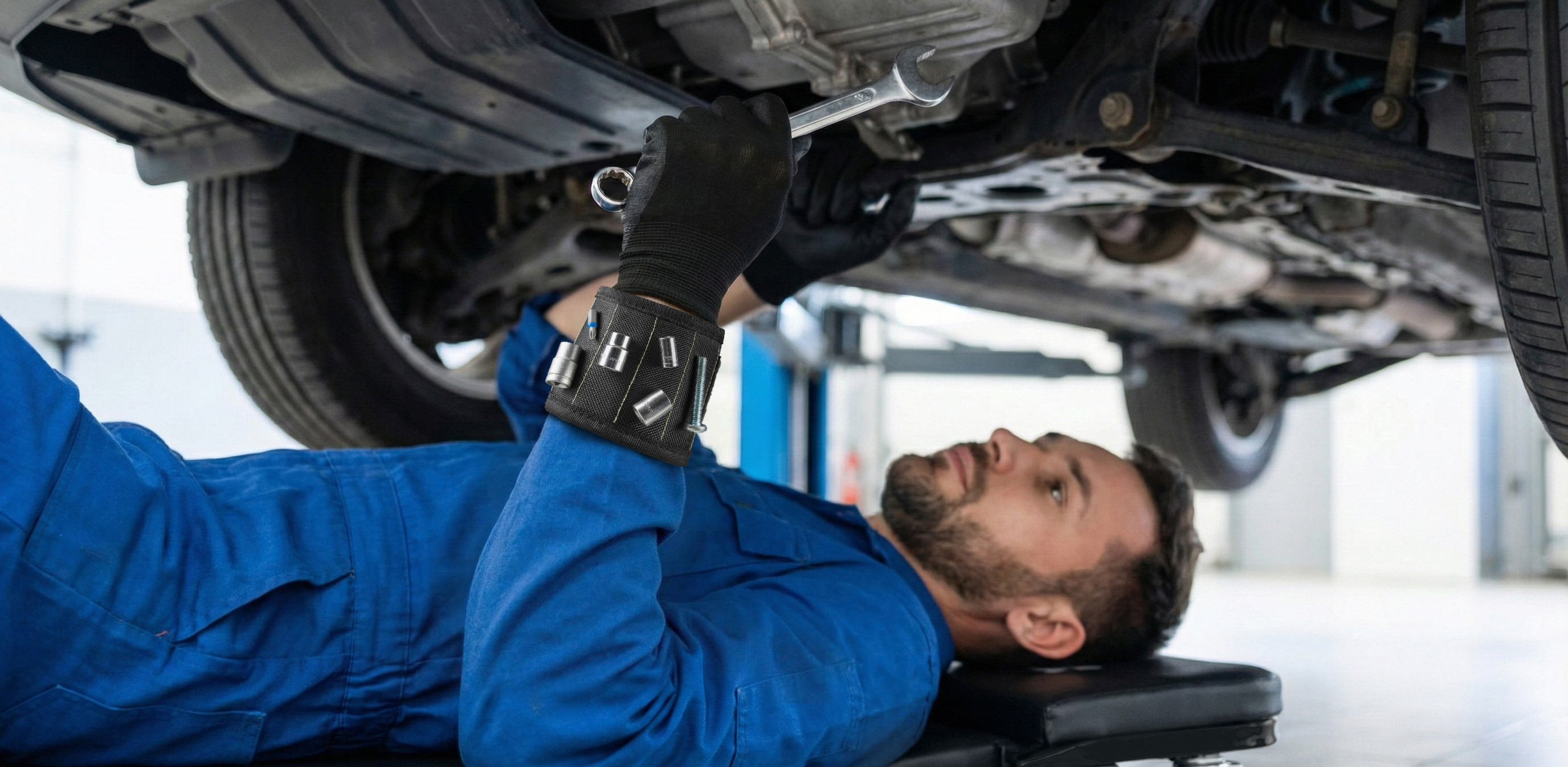 Wide panoramic view: mechanic rolling on the Autozas Black creeper for full-body under-vehicle access in a home garage