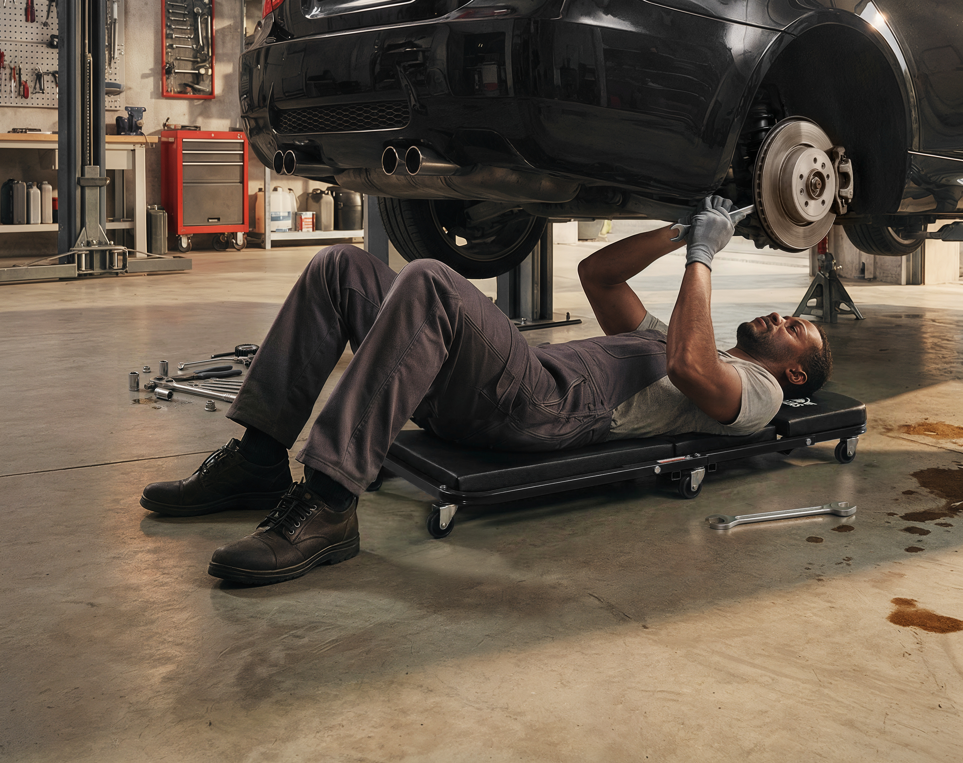 Fully equipped professional automotive workshop with Autozas Black 2-in-1 stool positioned at the steel workbench