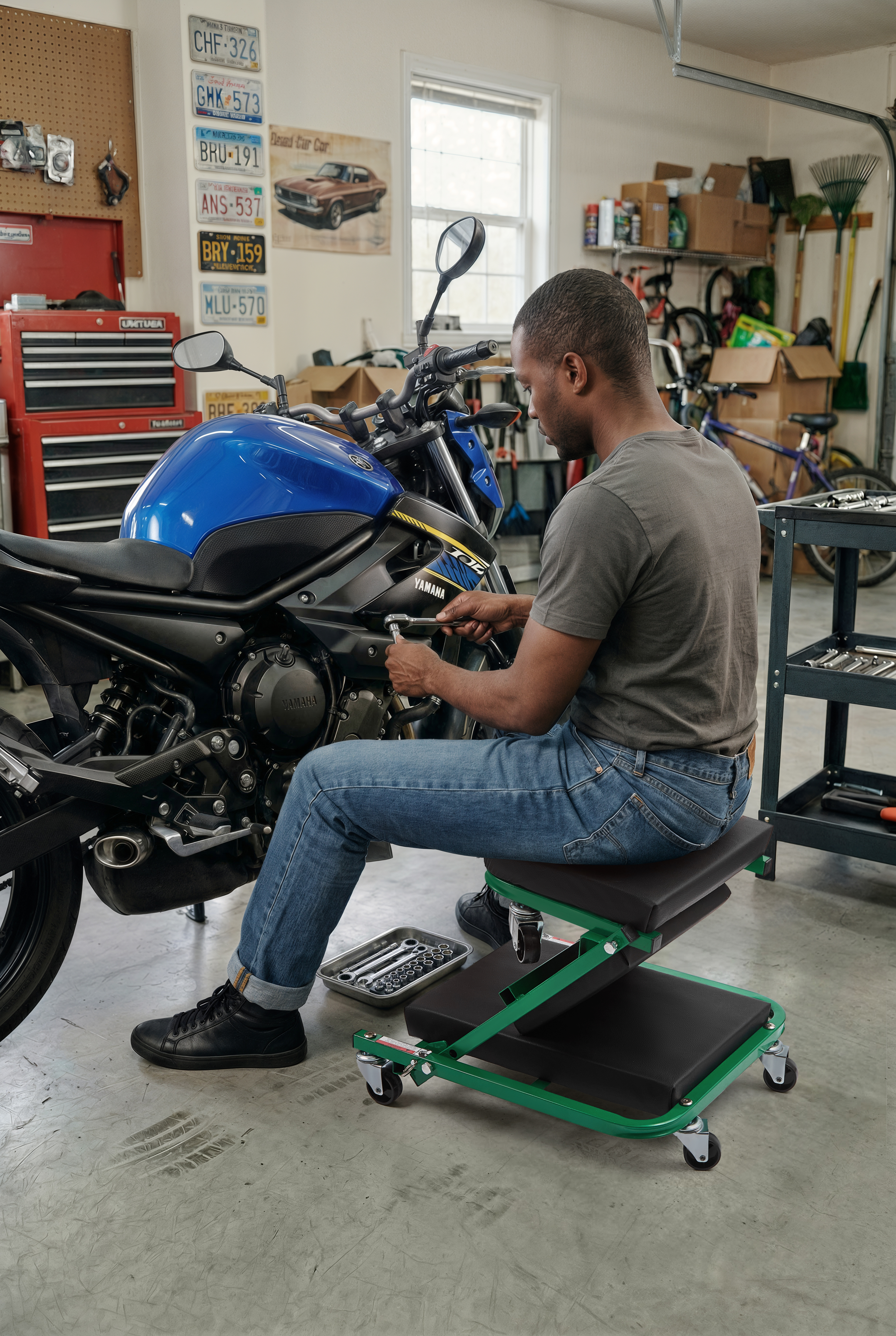 Mechanic seated on Autozas Green shop stool servicing a Yamaha motorcycle engine in a home garage